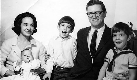 A black and white portrait of a family with a mother, father, and three young children