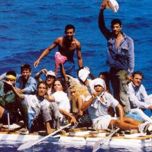 Film still from 'Balseros.', featuring a group of people on a small make-shift raft at sea.