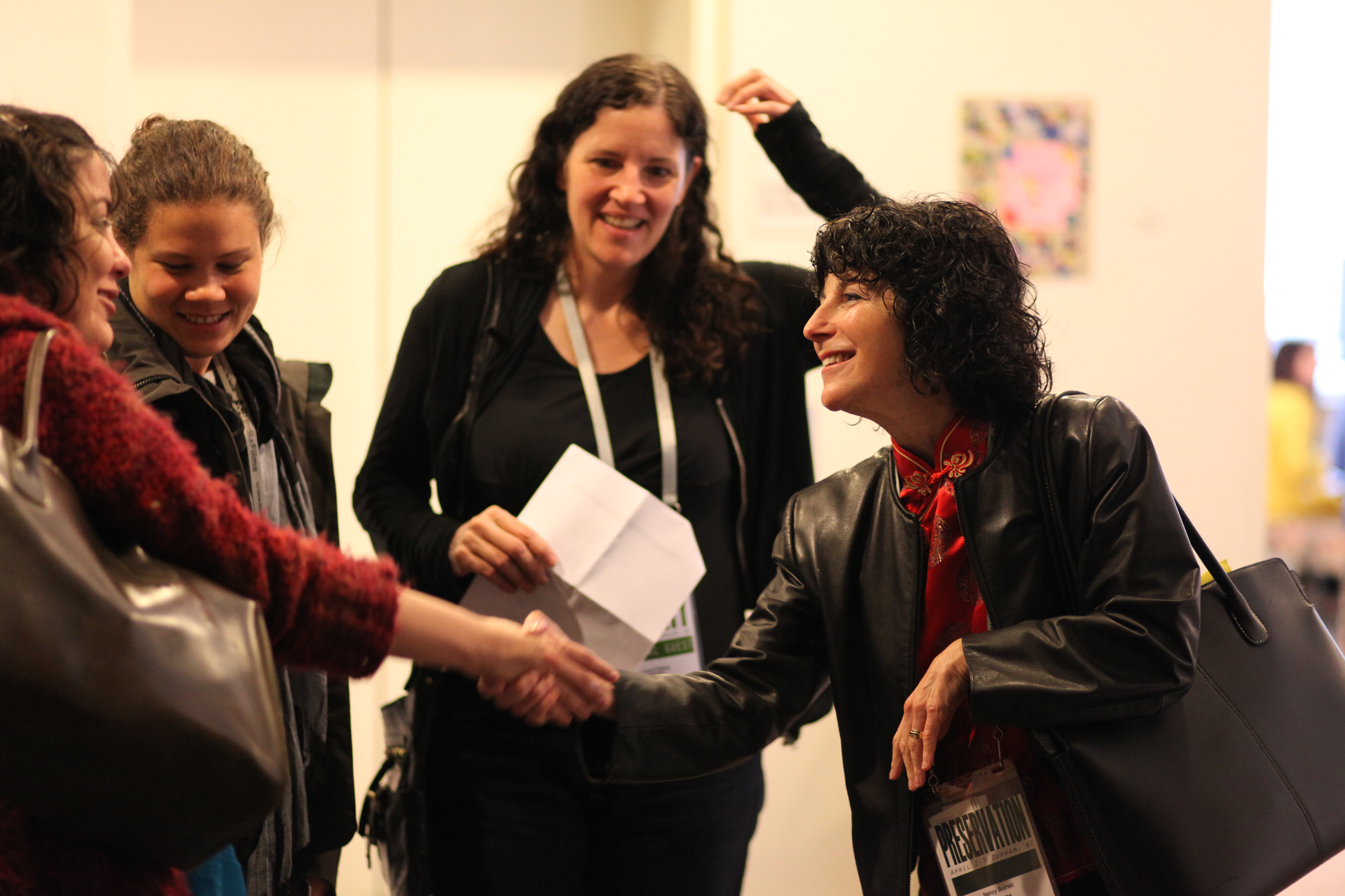 Photograph of Nancy Buirski greeting festival guests, with Laura Poirtras looking on, at Full Frame in 2009. Photo credit: Steve Bognar