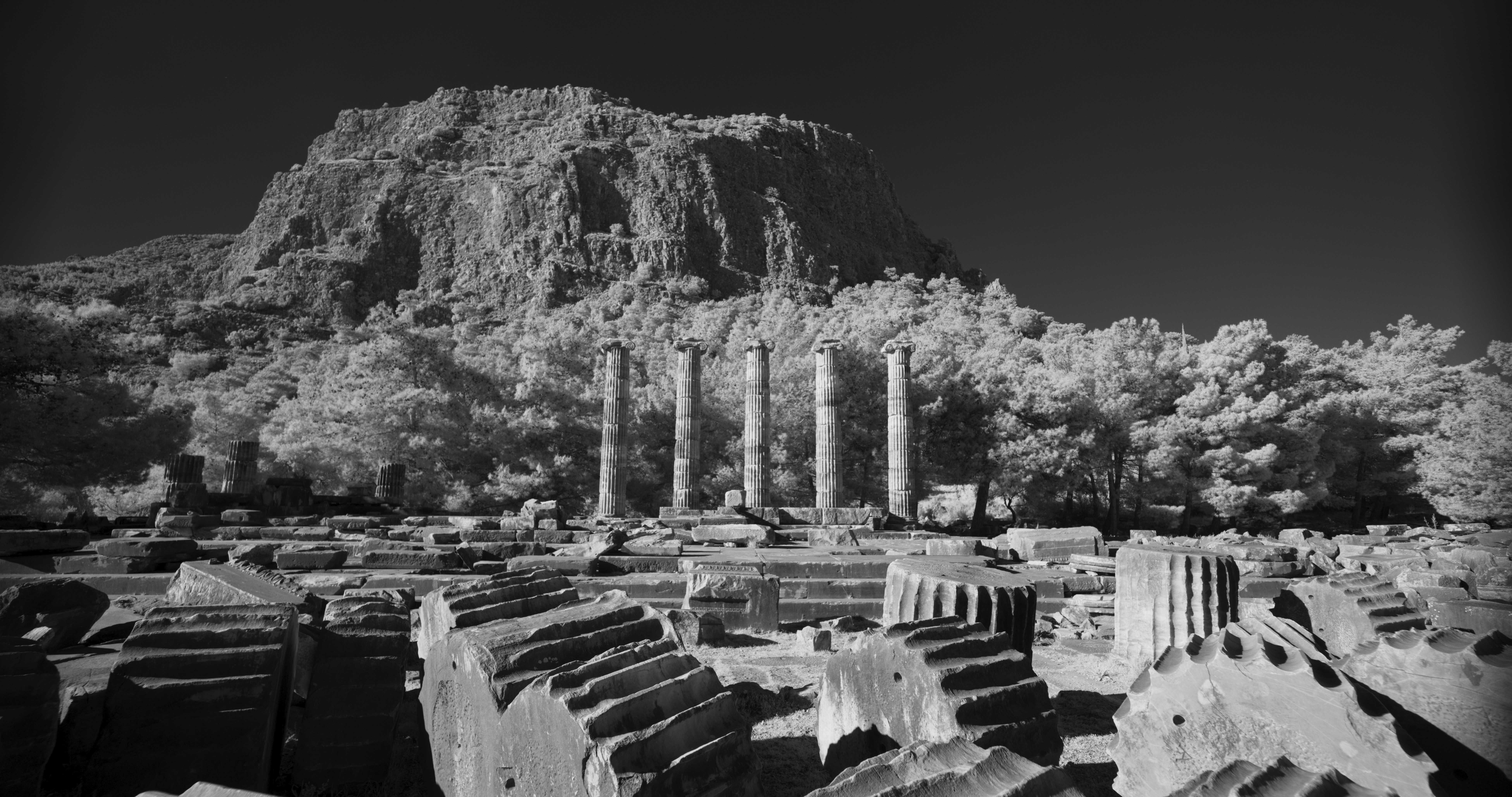 A mountain rises in the distance of ruins.