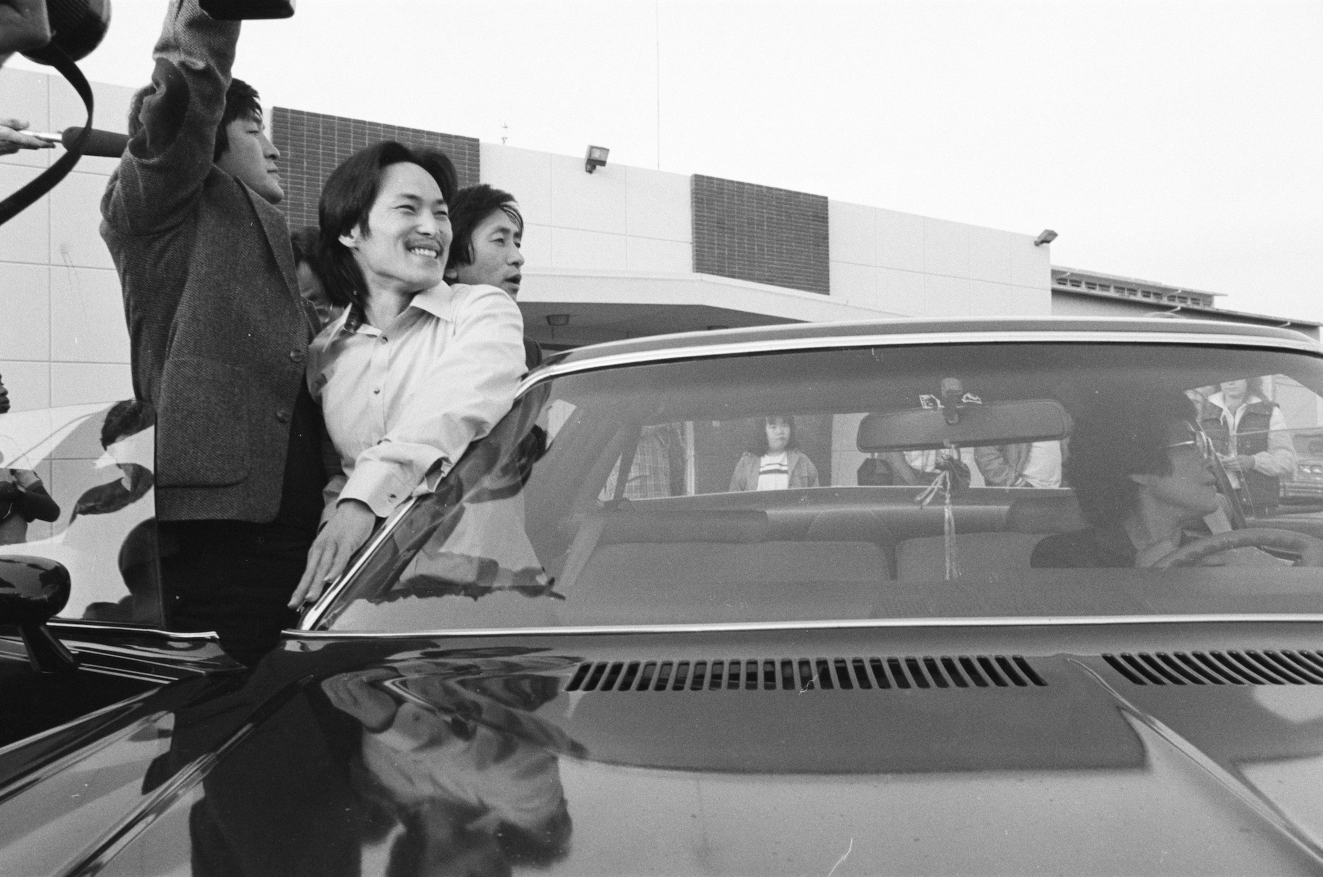  A black-and-white photo shows Chol Soo Lee, an Asian American male, smiling outside of a car after being released from prison. From Julia Ha and Eugene Yi's ‘Free Chol Soo Lee.’ Photo courtesy of Grant Din./ITVS