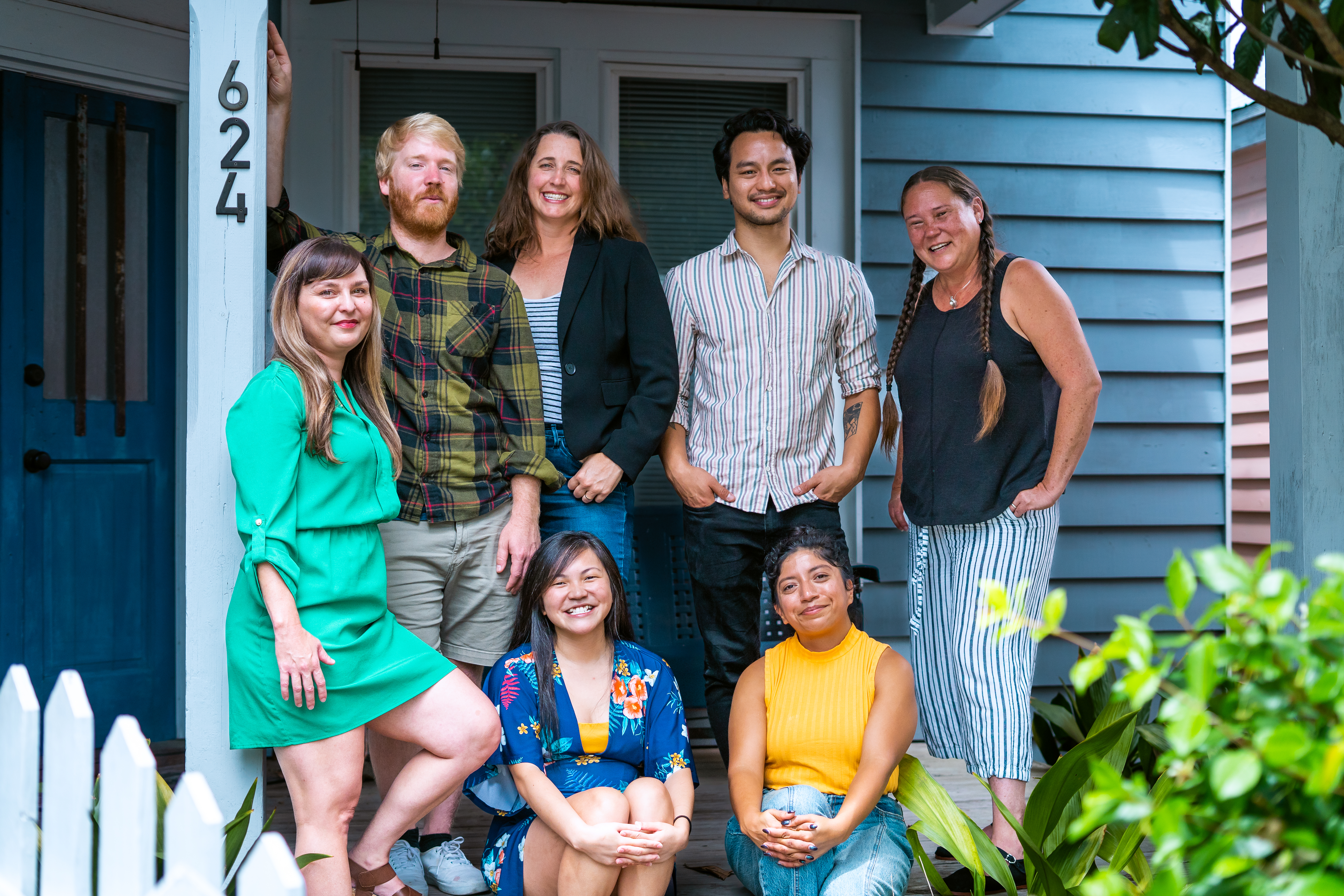 The Working Films staff, posing in front of a blue house: (Standing L-R) Molly Murphy, Andy Myers, Anna Lee, Gerry Leonard, Stephanie Avery. (Seated L-R) Hannah Hearn, Amalia Renteria. Photo by Tory Silinski.