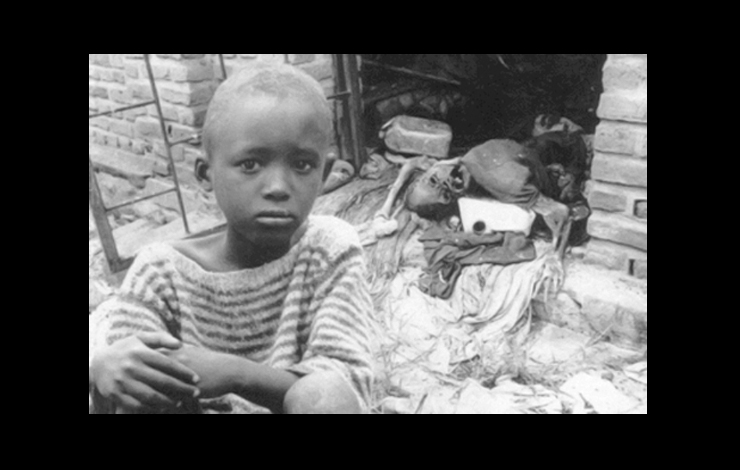 A child looks sadly; there's a corpse in the background. From Daniele Lacourse and Yvan Patry's 'Chronicle of a Genocide Foretold.' (Canada, 164 min., 1996)