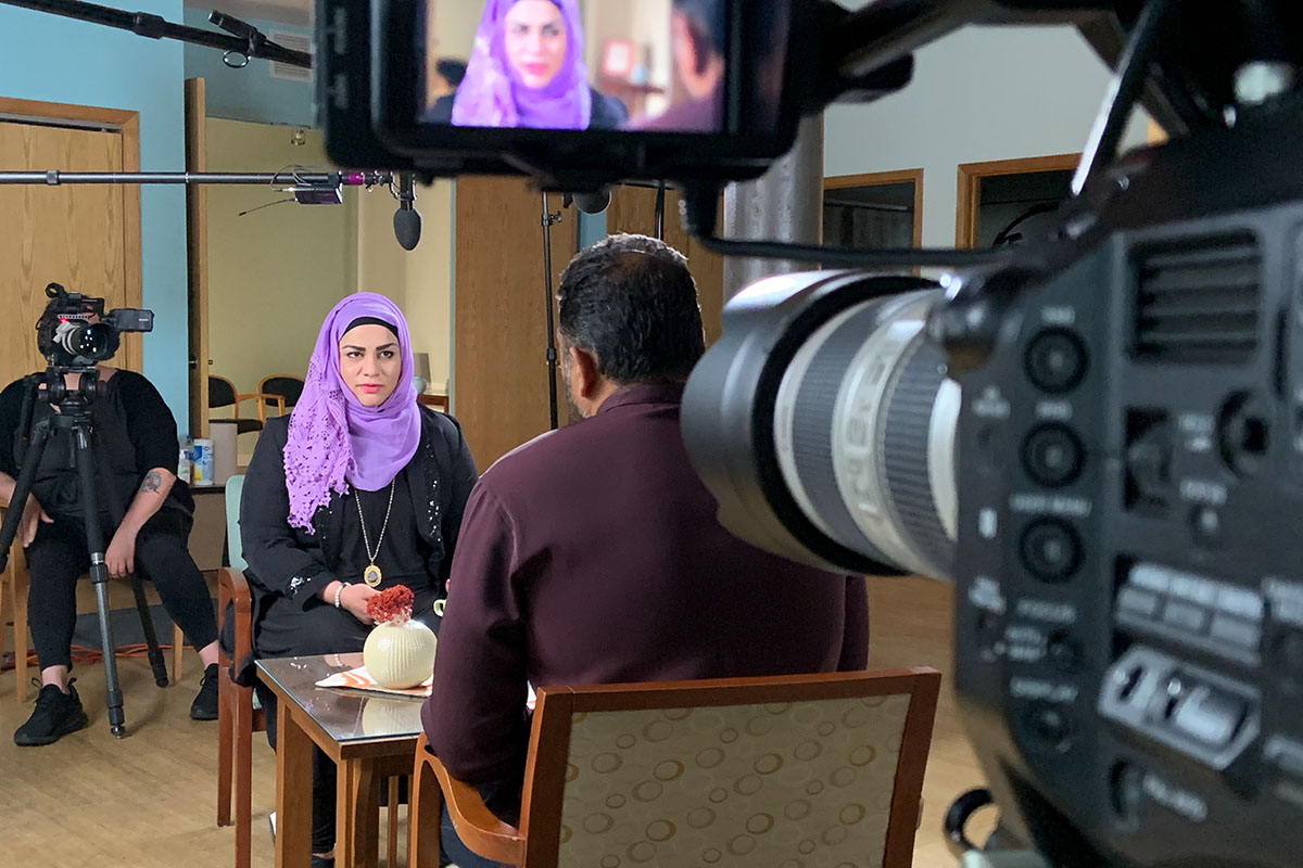 A BTS photo of a female participant, wearing a purple headscarf, being filmed for the screening guide, 'Healing the Healers.' Courtesy of Transform Films.