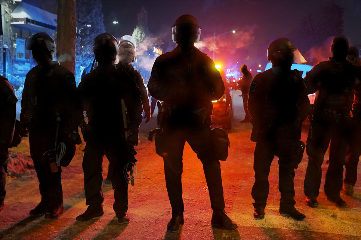 A line of uniformed policemen silhouetted against streetlights. From Mike Shum’s ‘Police on Trial.’ Courtesy of FRONTLINE (PBS). 