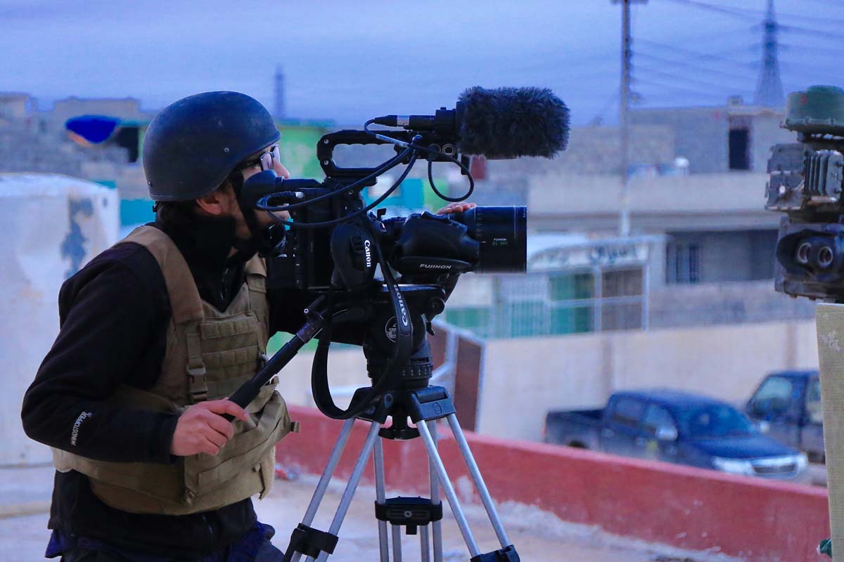 The late Brent Renaud, wearing a protective helmet and bulletproof vest, filming on a rooftop. Photo courtesy of Jeff Newton
