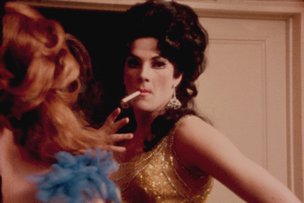 A drag performer in a golden dress, wearing a wig, smoking a cigarette. From Frank Simon's 'The Queen.' Courtesy of Kino Lorber.