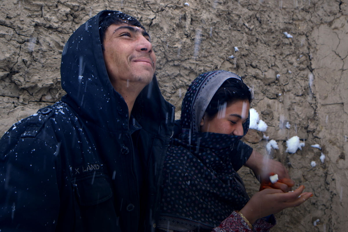 A young Afghan couple pictured in the snow. Image from Elizabeth and Gulistan Mirzaei’s ‘Three Songs for Benazir,’ which was set and filmed in refugee camps in Afghanistan. Courtesy of the filmmakers.