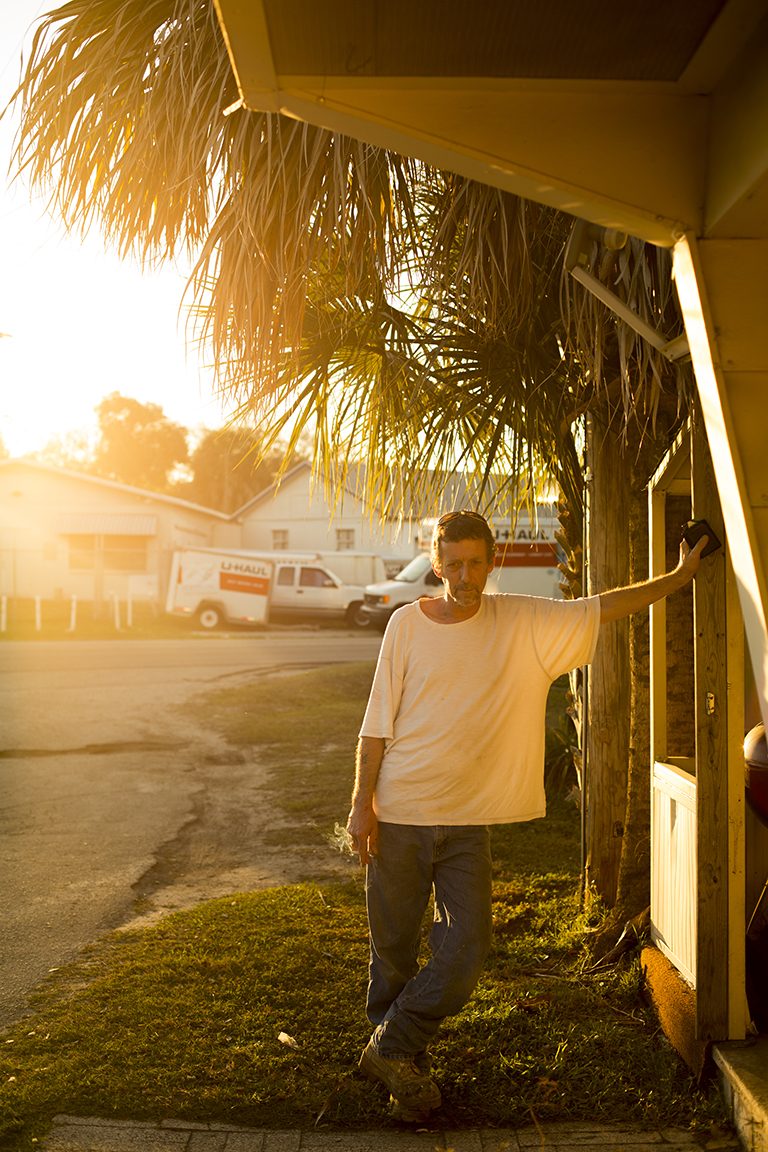 A white man is standing at the entrance of a trailer park