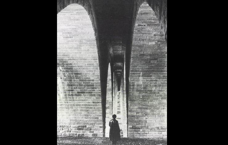 A silhouette stands under a brick archway of the Bridge piers at the Saale river, 1937.