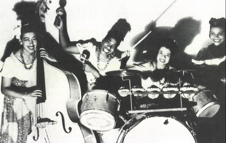 Four women smile while holding instruments.  From The International Sweethearts of Rhythm by Greta Schiller and Andrea Weiss.