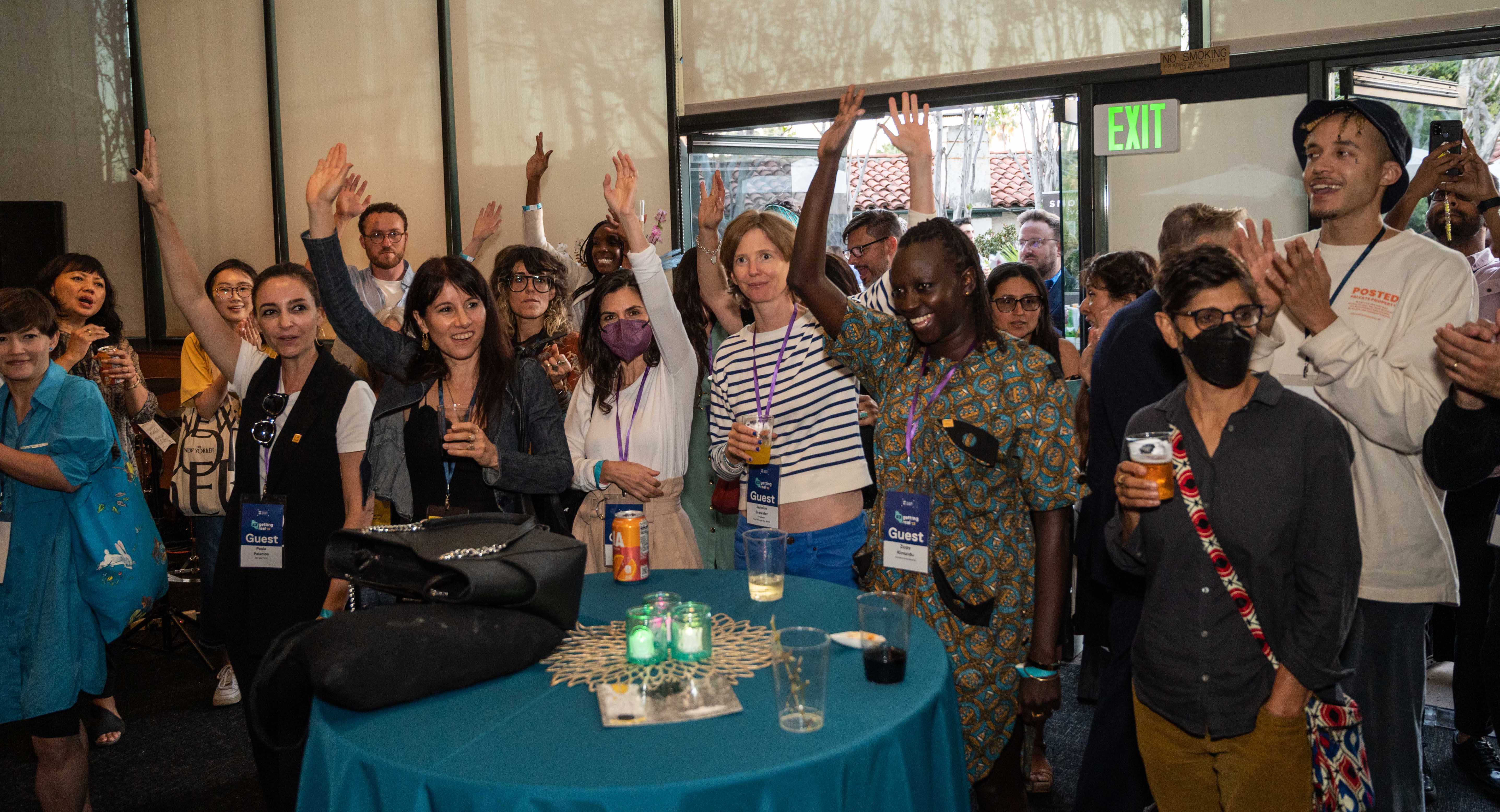 IDA Grantees raising their hands at the IDA Grantee Reception during Getting Real '22 on September 29, 2022 at the Director's Guild of America, Los Angeles. Photo courtesy of Urbanite Media LA.