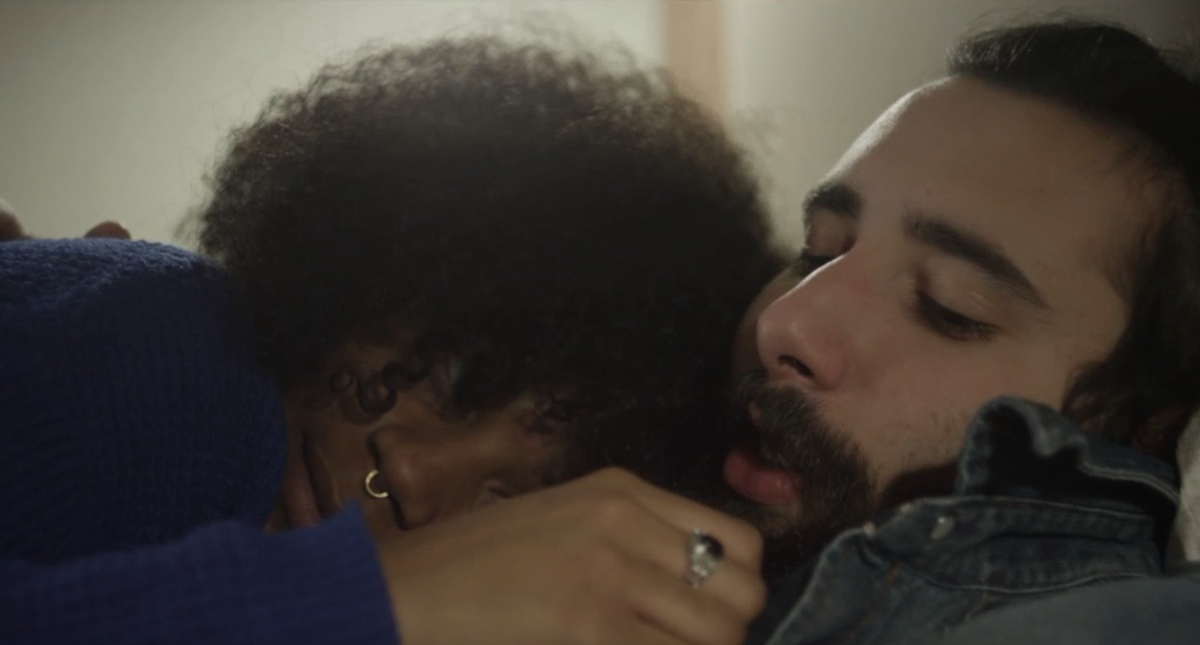 A young Black woman in a blue sweater seen lying against a young, bearded white man. From Alice Diop's 'Vers la tendresse.' Courtesy of Mubi. 