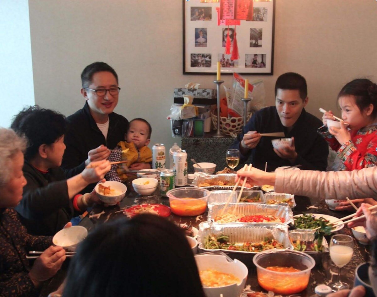 Filmmaker Hao Wu is a Chinese American male. Seen here sitting and eating at a table with his child, his family members, and partner. From Hao Wu’s ‘All in My Family.’ Courtesy of Netflix.