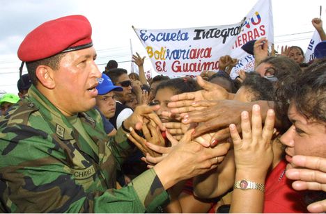 A middle-aged man in army fatigues and a red beret greeting crowds of people