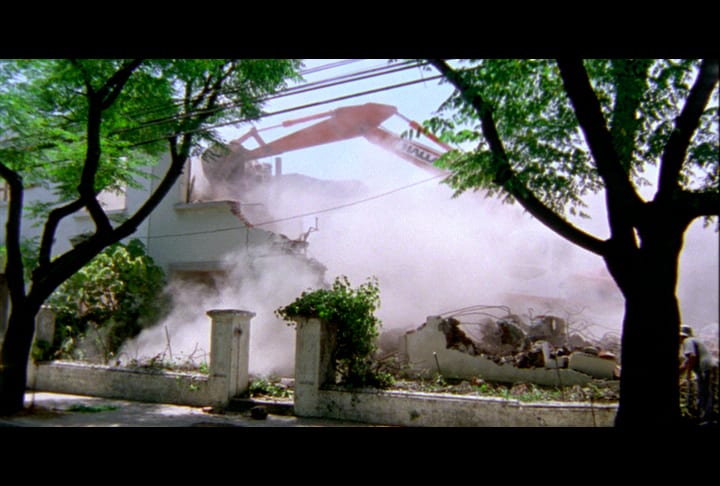 A bulldozer demolishes a building.