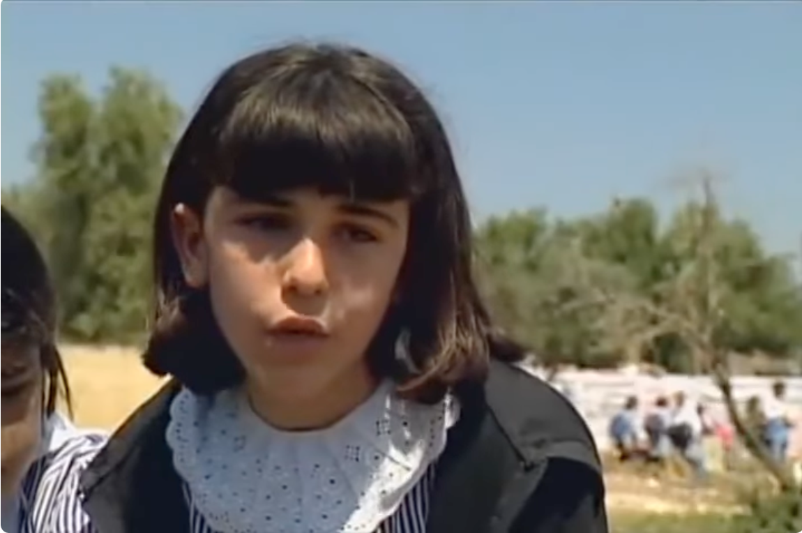 A young girl looks at the camera.