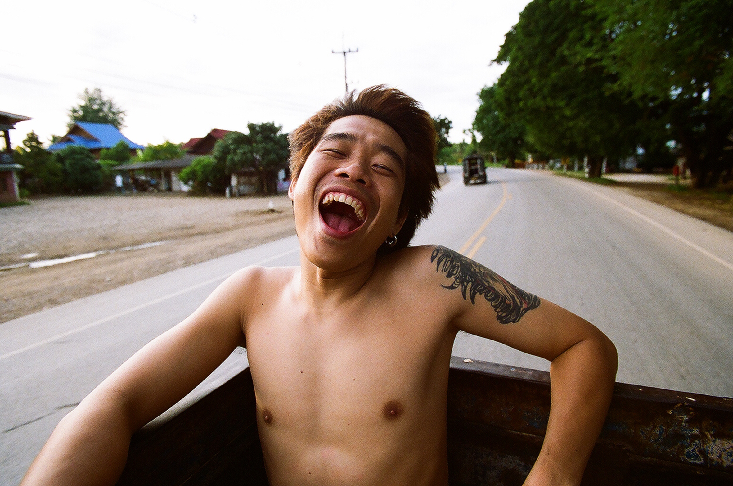 A young man in glee on the back of a truck.