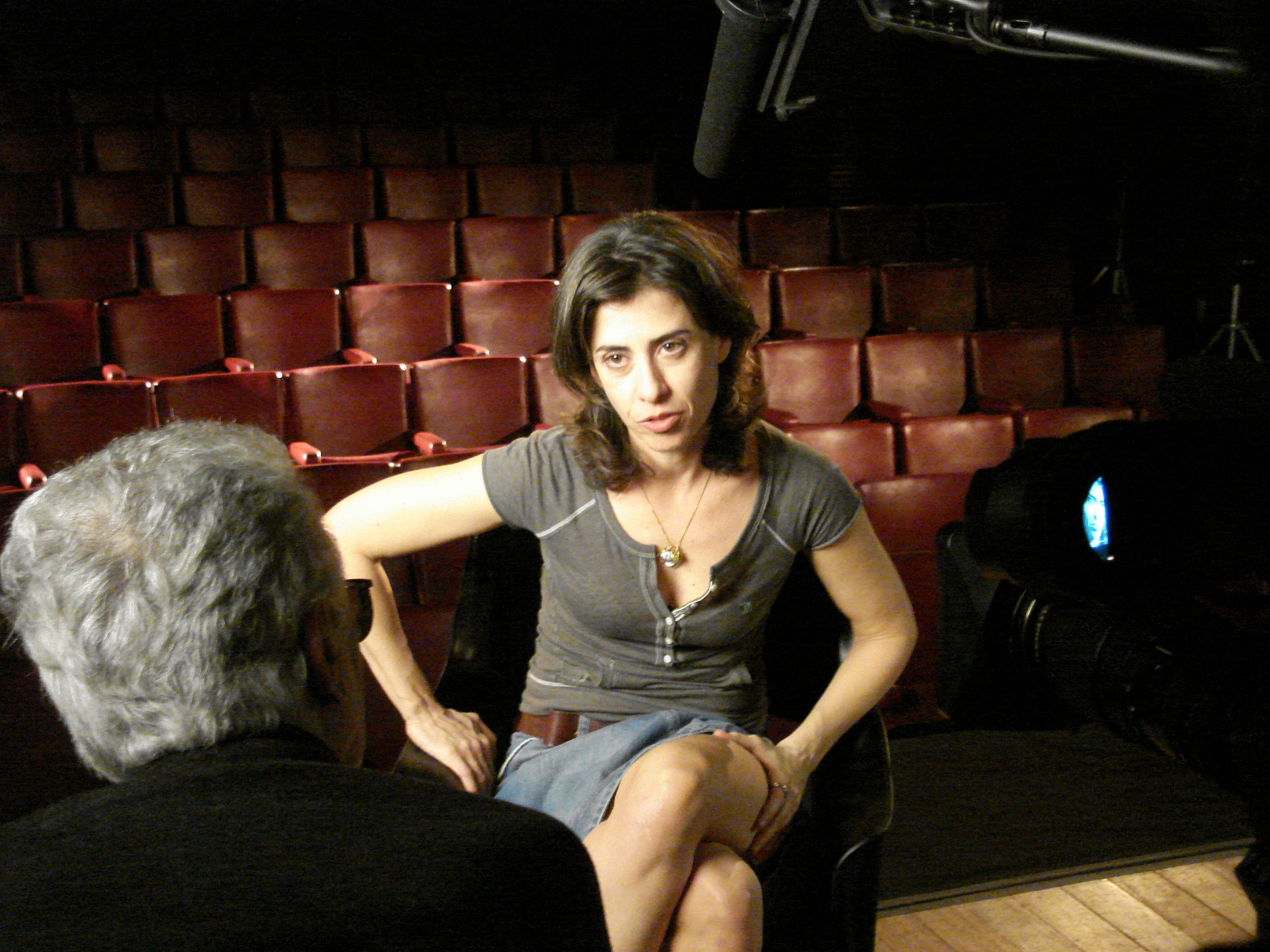A woman sits in a chair being interviewed by Eduardo Coutinho.