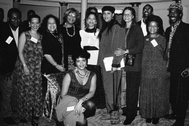 A black and white image of a group of people standing at an event