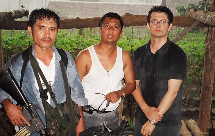 An armed guard (left) protects journalist Herman P. de la Cruz (center), editor of the 'Zamboanga Scribe,' with CameraPlanet producer Jack Youngelston by his side. Courtesy of CameraPlanet