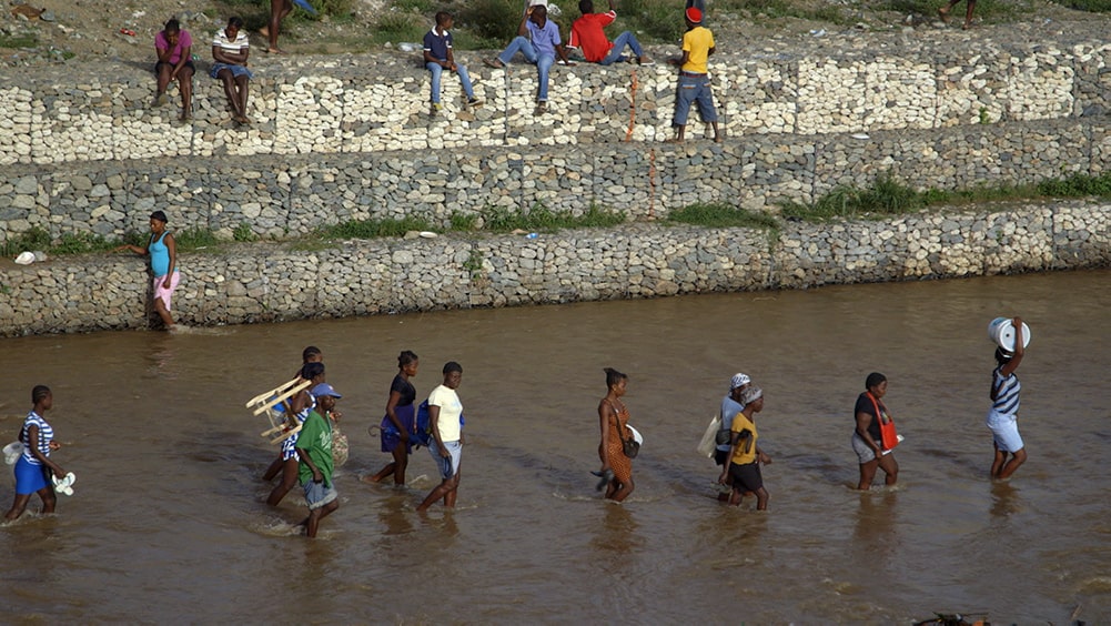 A group of people walking through a shallow river at the border between Haiti and the Dominican Republic. From Michele Stephenson's 'Stateless.' Courtesy of National Film Board of Canada.
