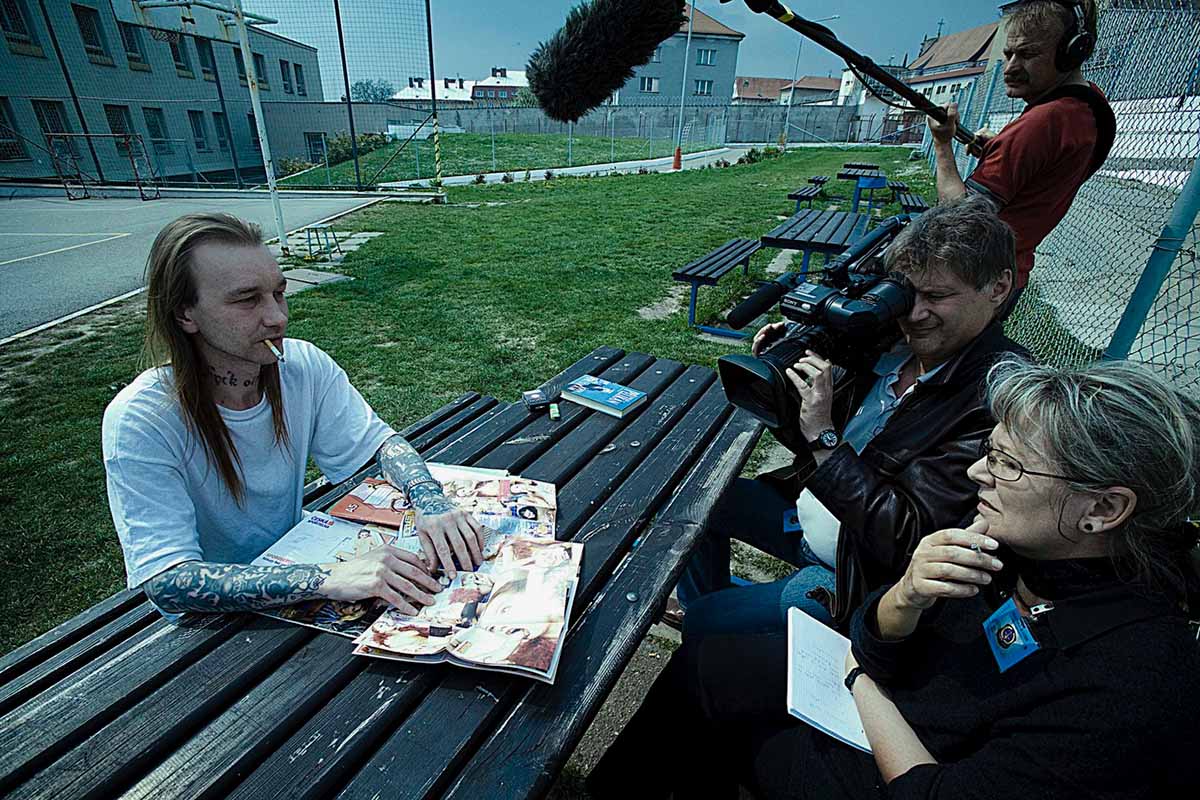René is a Czech man with long hair and tattooed sleeves. He is being filmed by the film crew. Image from Helena Třeštíková’s ‘René – The Prisoner of Freedom.’ Courtesy of IDFA.