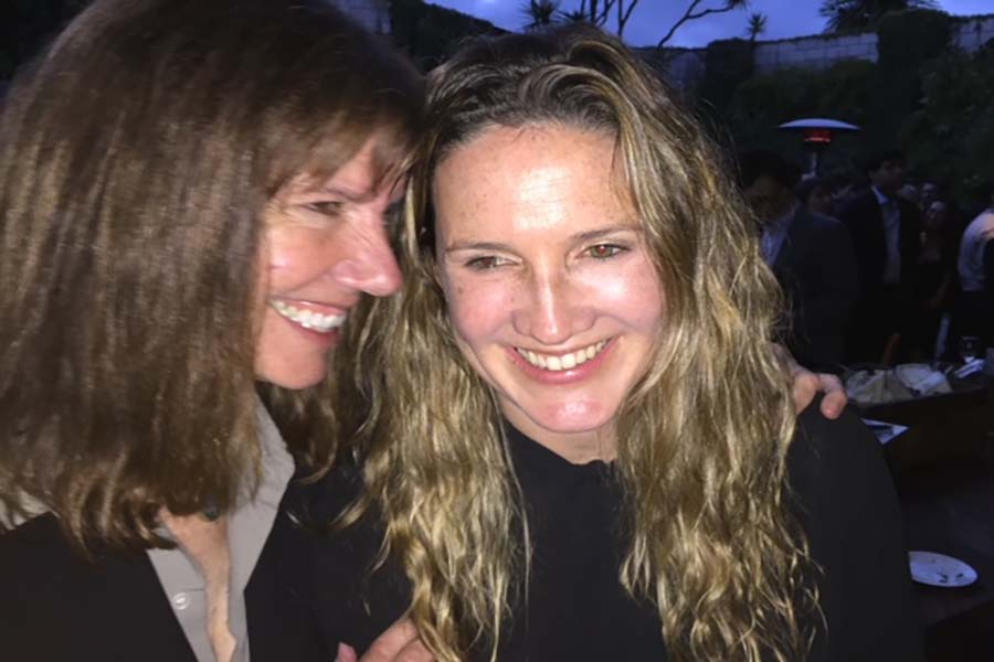 Diane Weyermann and Courtney Sexton, both wearing black, exchanging smiles. Courtesy of Courtney Sexton.
