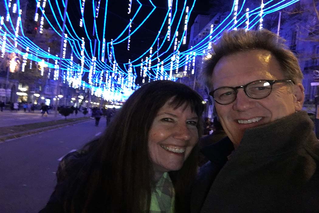 Diane Weyermann and Ted Braun standing against a backdrop of blue lights in Spain. Courtesy of Ted Braun.