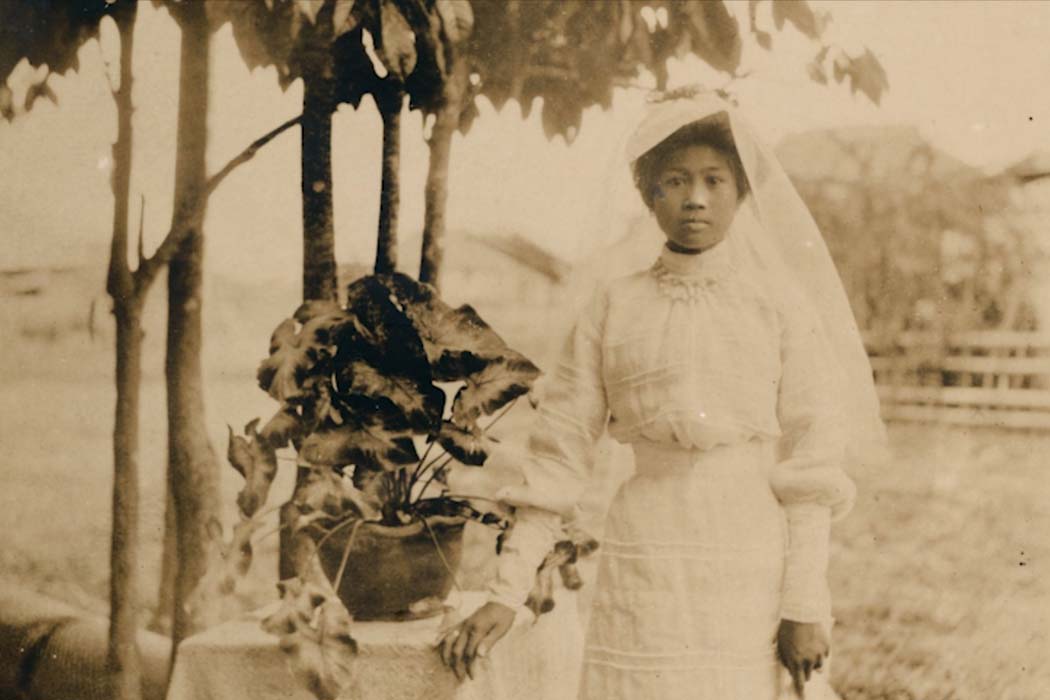 An archival image of a child bride from the Philippines standing next to a plant. From Shireen Seno’s ‘To Pick a Flower.’ Courtesy of Shireen Seno