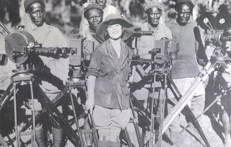 Osa Johnson, a woman surrounded by cameras and men, during filming of 'The Blue' (circa 1926).