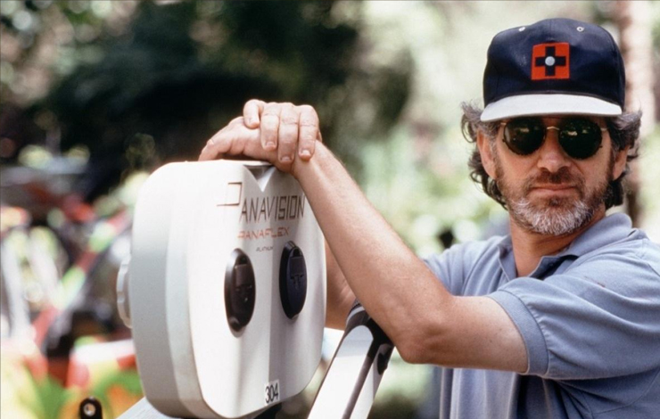 Steven Spielberg leans on a Panavision camera. 
