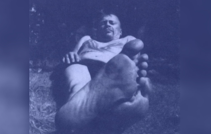 A man looks down at the camera with his foot in the forefront of the frame, from Tahvo Hirzonen's 'Tino.'