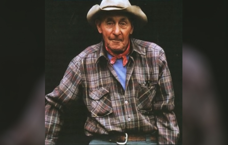 A man wearing a flannel and cowboy hat from 'Woodsmen and River Drivers.'
