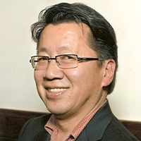 An Asian man with dark short hair and glasses.