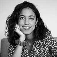 A black and white picture of a woman with light skin and dark long hair.