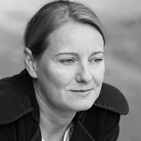 A black and white portrait of a woman with light skin and short light hair.