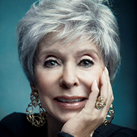 An older woman with light skin and white short hair.