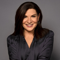 A woman with light skin and long dark brown hair.