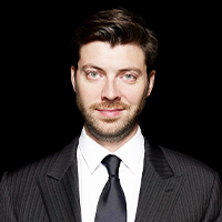 A man with light skin, dark hair and facial hair.