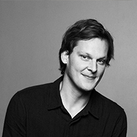 A black and white portrait of a man with light skin and dark black hair.