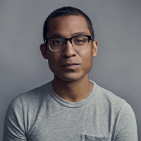 A biracial Asian and African American man with glasses looking into the camera.