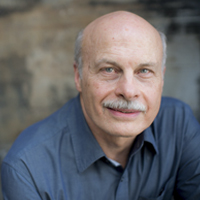 An older man with light skin, a gray mustache and bald head.