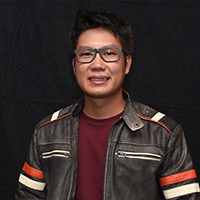 An Asian man with dark hair and gray glasses.