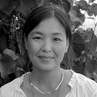 A black and white portrait of an Asian woman with medium length dark hair.