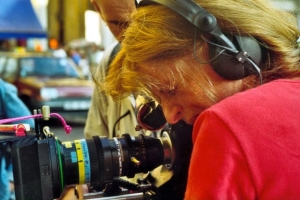 Photograph of Claire Simon looking through a camera viewfinder.