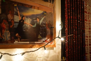 Image of a photo board on the wall, with a picture of a dancing couple pinned onto it, and string lights in the foreground