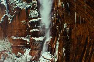 Snow tumbles over a cliff edge in Zion National Park.