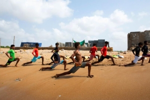 A group of men doing lunges on the beach