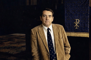 A picture of Rev. Raymond Judd Jr. in the late 1970's, standing next to the pulpit in the Trinity Chapel that he preached on for over 30 years.